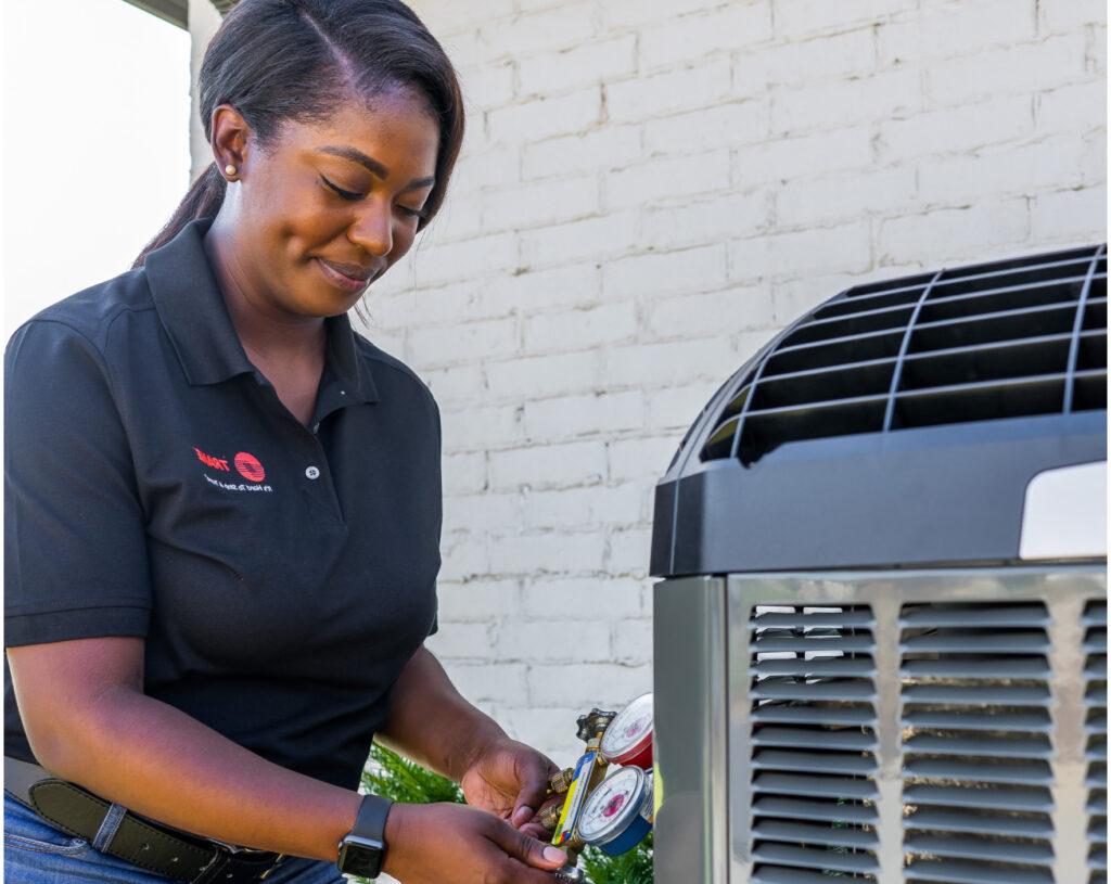 A Trane HVAC technician takes a measurement from an air conditioner.