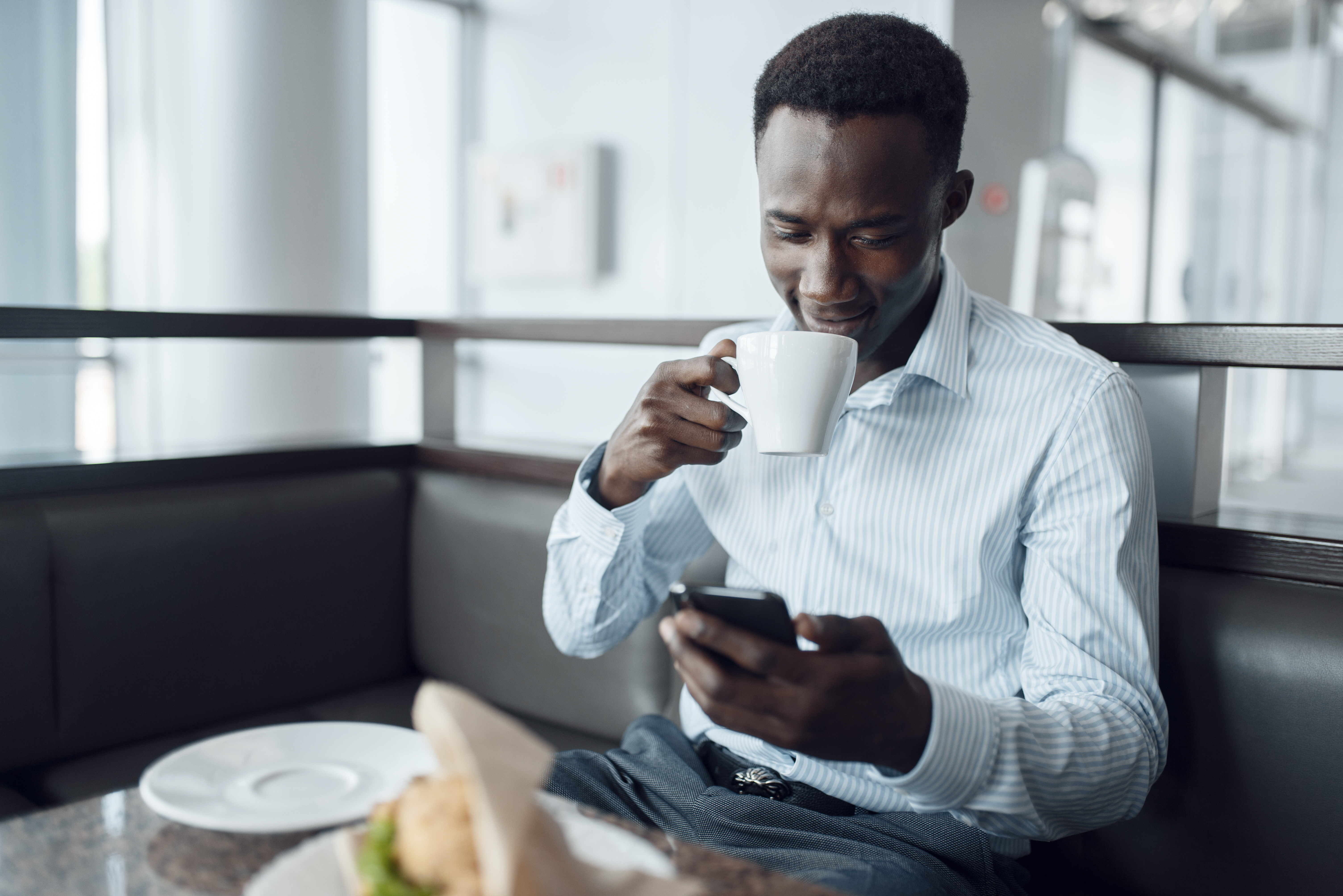 Ebony businessman having lunch in office cafe