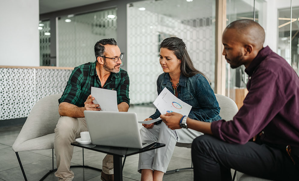 Casual meeting of diverse business team analyzing financial data