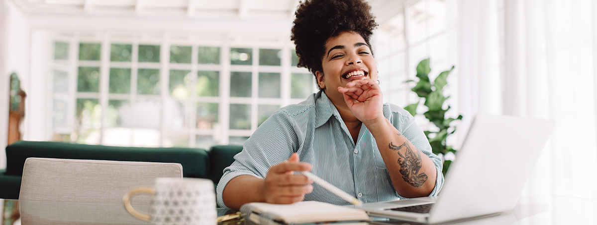 Cheerful woman sitting at home office desk