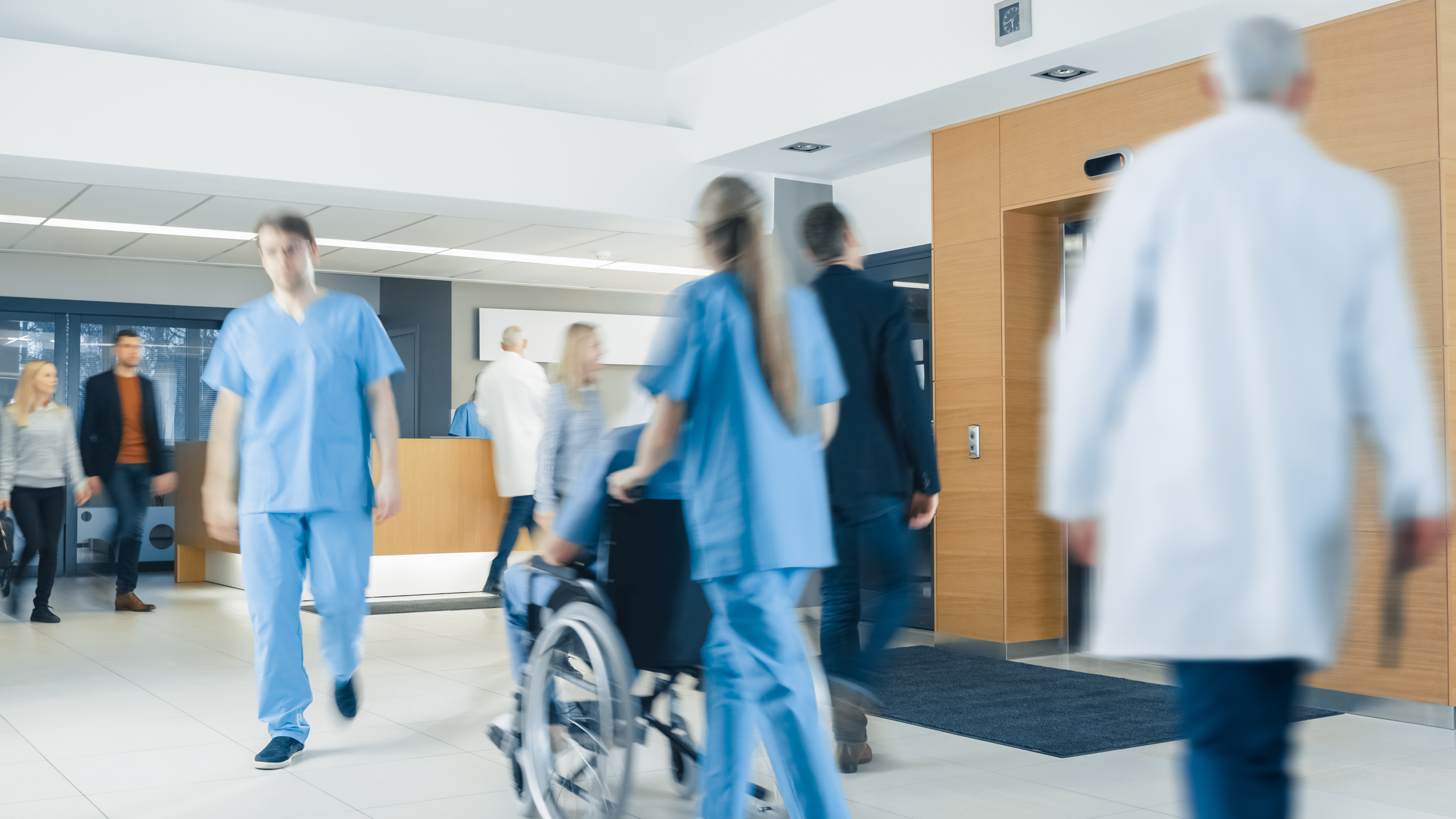 Hospital Lobby. Doctors, Nurses, Assistant Personnel and Patients Working and Walking in the Lobby of the Medical Facility.